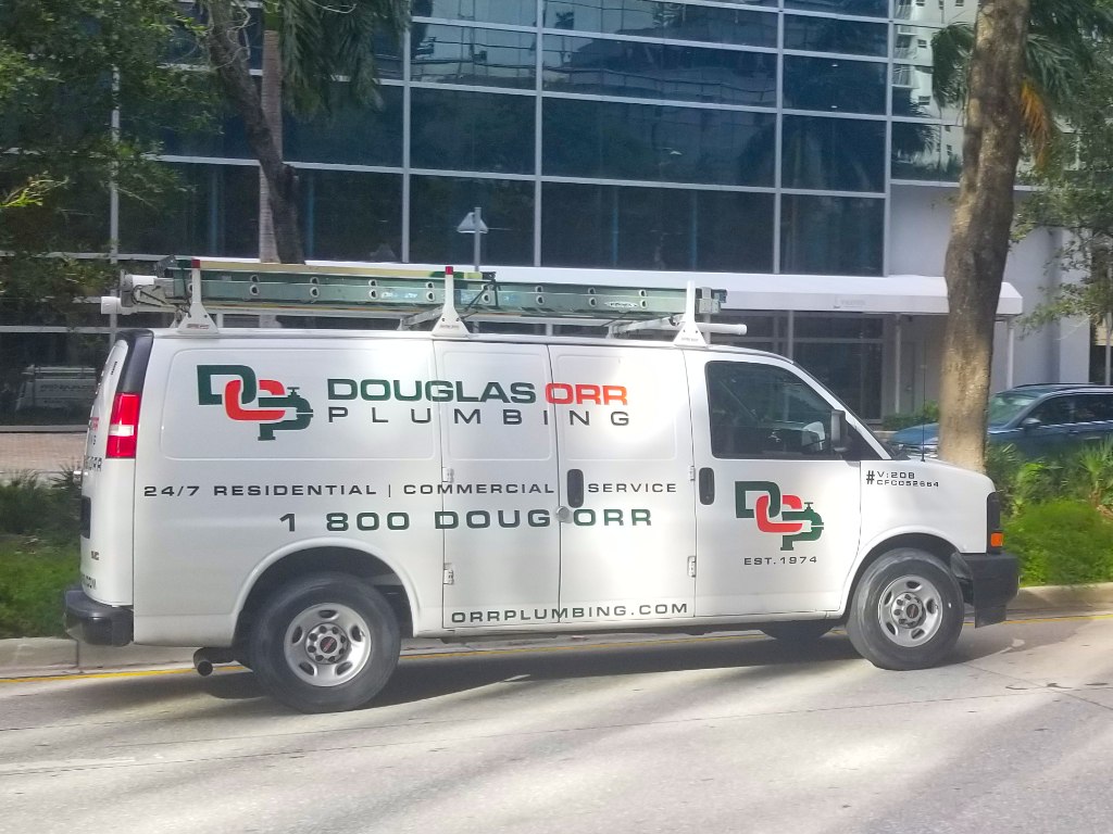 A group of contractors in work attire traveling together on a in a company van through Brickell Ave, Miami.