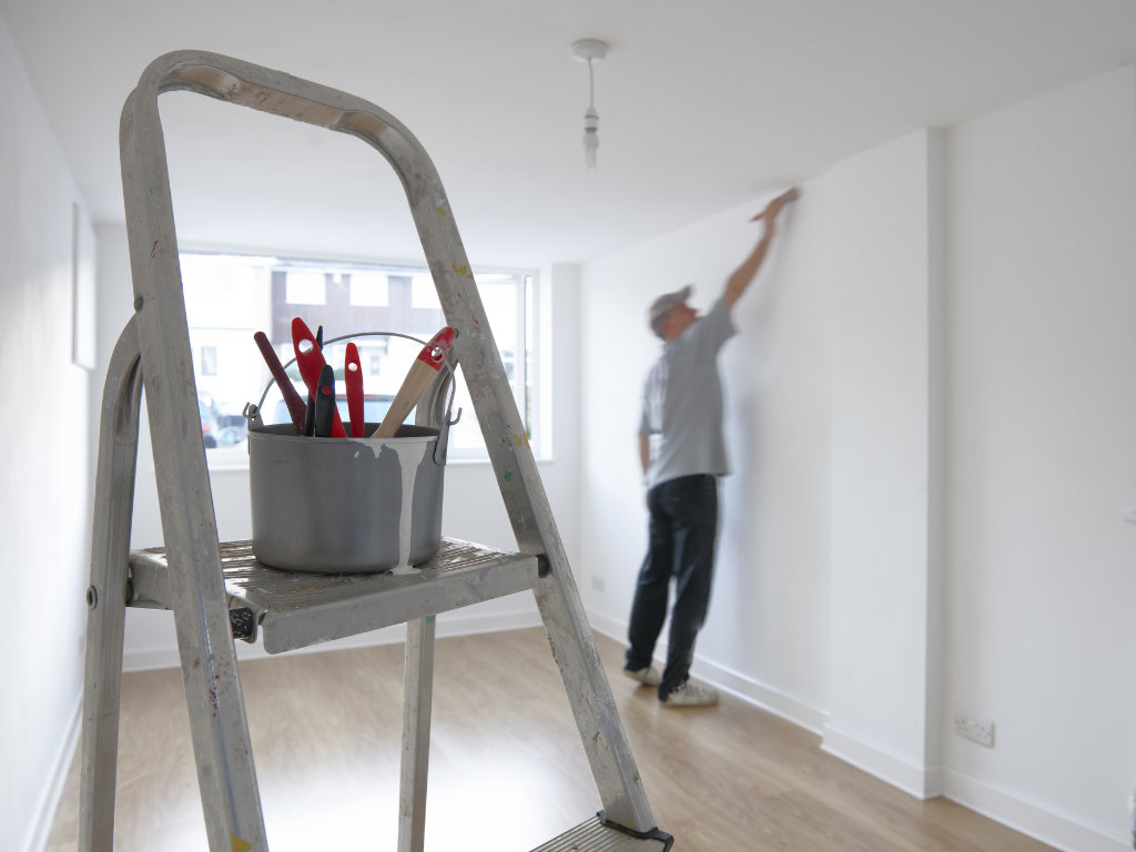 Contract Painter, painting a home living room wall.