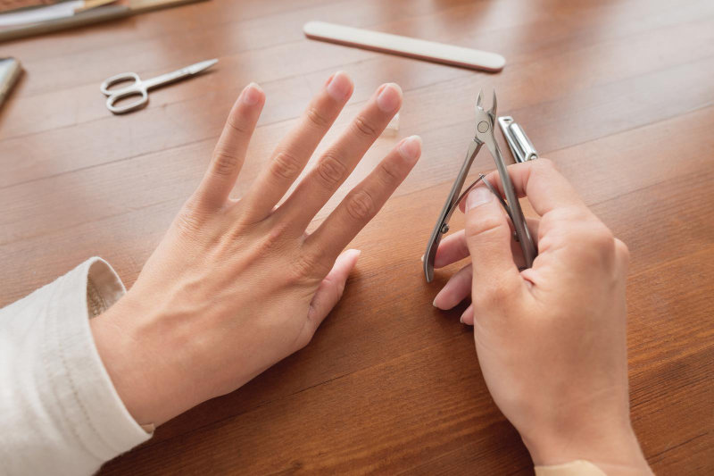 A woman performing a hand care and manicure treatment at home.