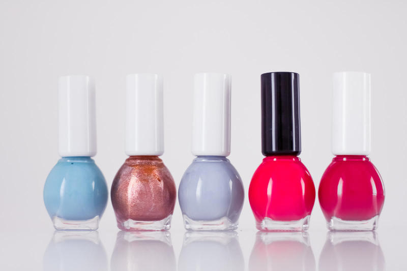 A collection of nail polish bottles arranged neatly on a white surface.