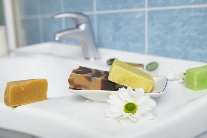 Raft organic soap bars on washbasin in the home bathroom.