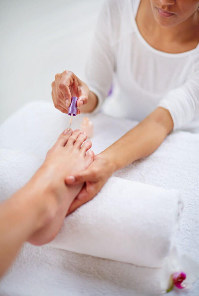 A close-up shot of a woman's feet being pampered during a pedicure in a health spa.