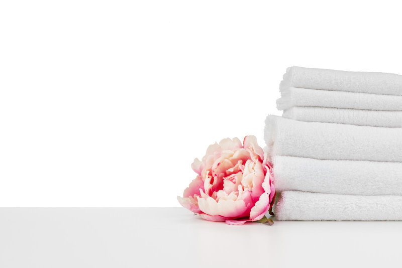 A spa composition with towels and flowers isolated on white.