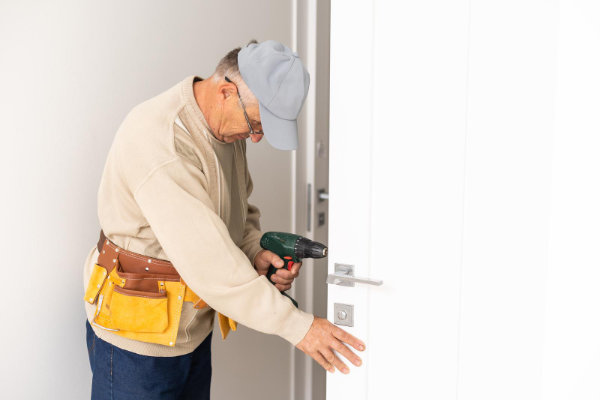 Professional locksmith adjusting a white lock on a plastic window installation