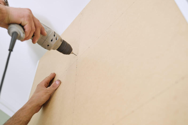 Worker's hand with professional tools installing furniture