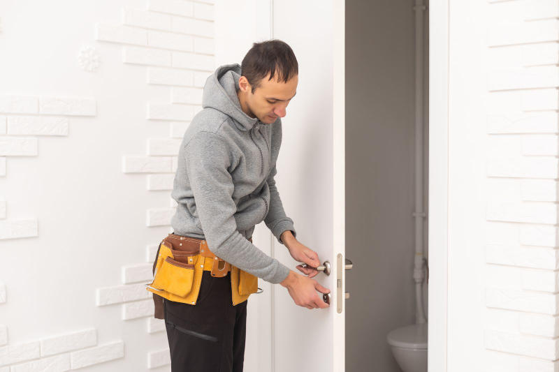 Male carpenters installing an interior door with a wooden frame