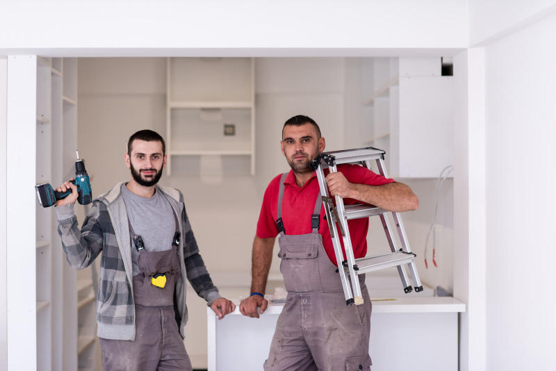 Young workers installing a new kitchen